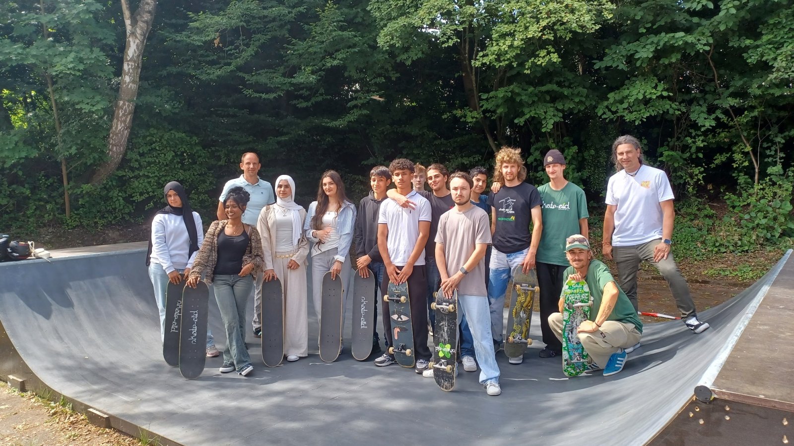 Schülerinnen und Schüler stehen auf einer Skatebord-Rampe