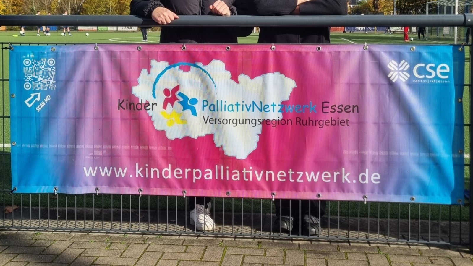 Eine Bende des KinderPalliativnetzwerks mit zwei Personen auf dem Fußballplatz