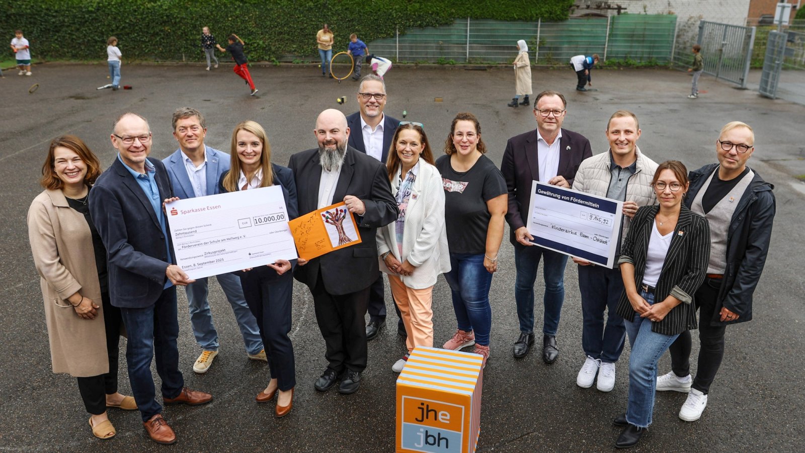 Mehrere Personen  stehen auf dem Schulhof