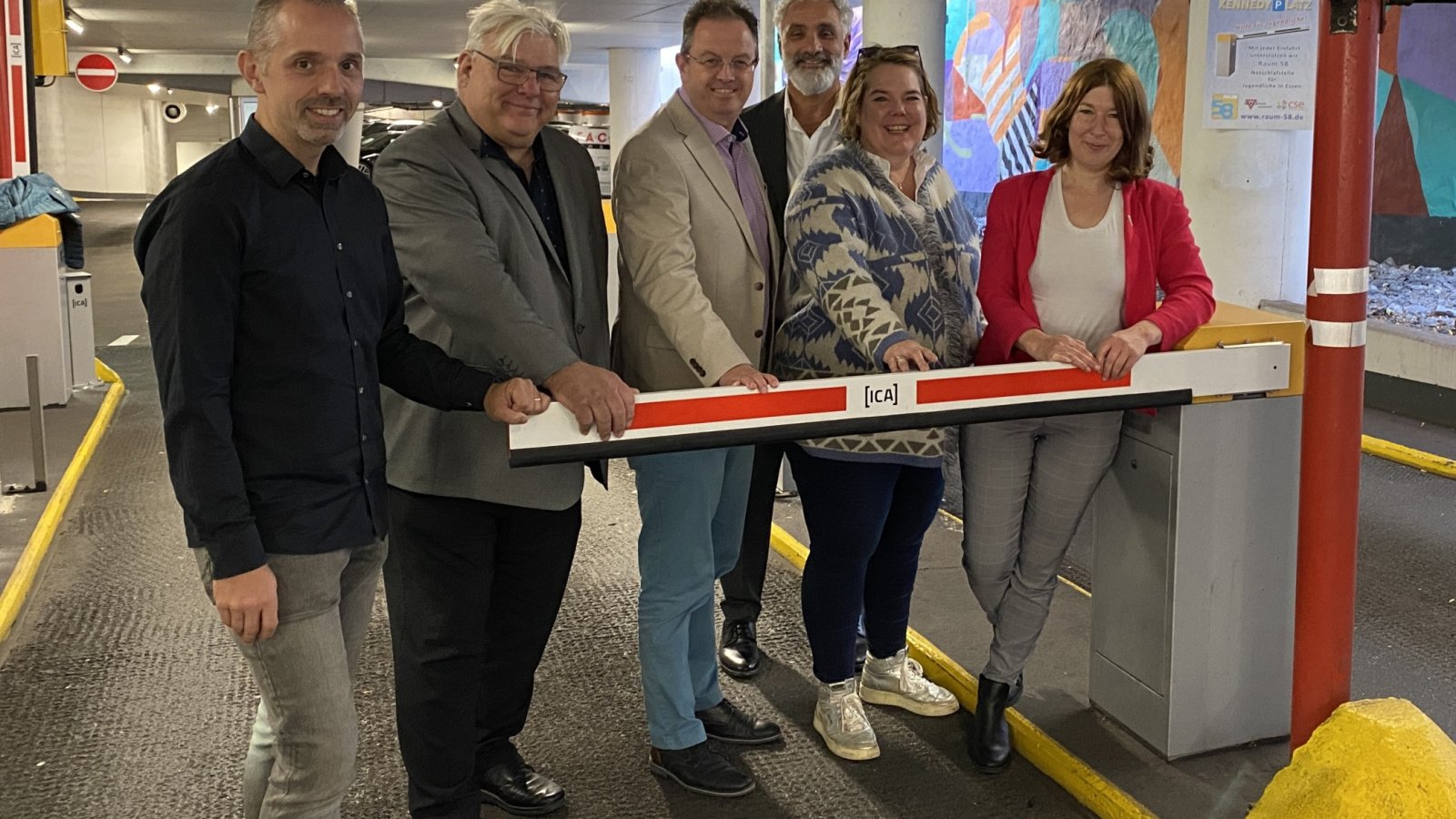 sechs personen stehen hinter einer Parkhaus-Schranke