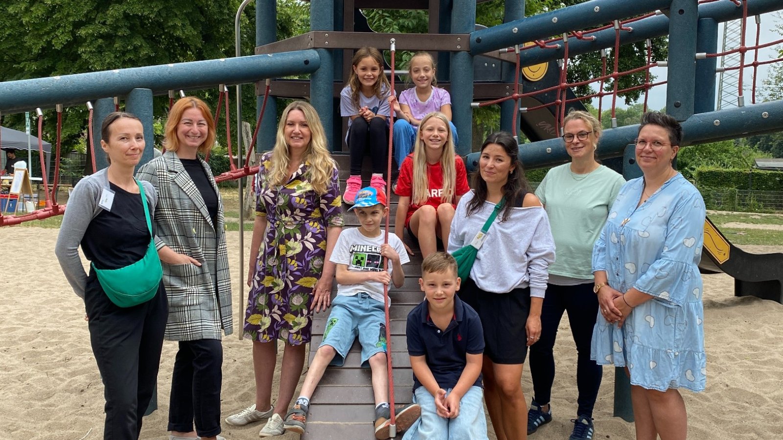 Mehrere Personen stehen auf dem Schulhof vor einem Spielgerät