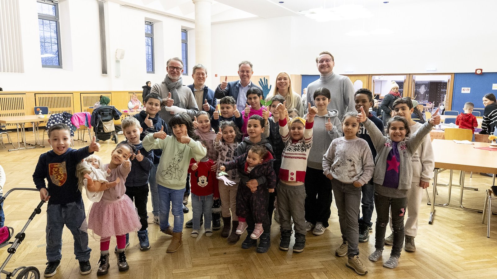 Gruppe von Kindern und Erwachsenen beim Kindertisch