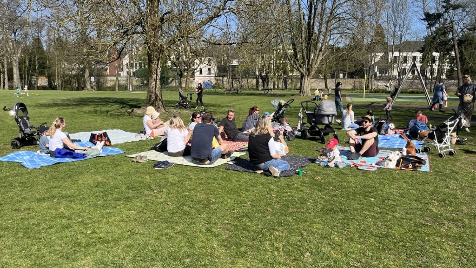 Familien auf Picknickdecken auf einer grünen Wiese