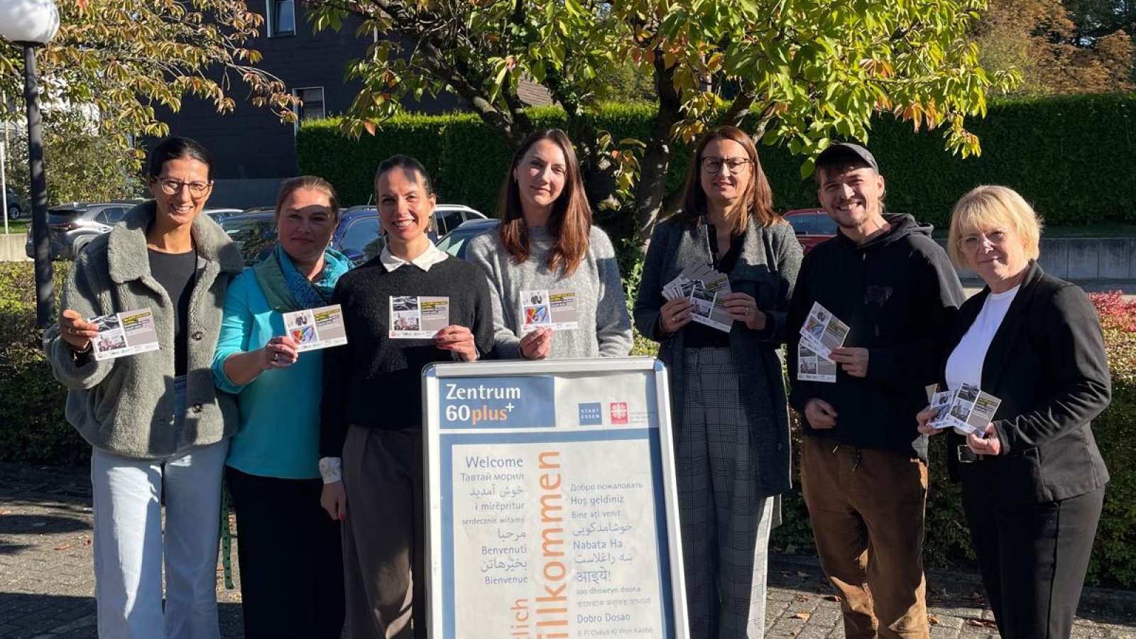 Das Team der Zentren 60plus mit Postkarten zum Weltseniorentag in der Hand