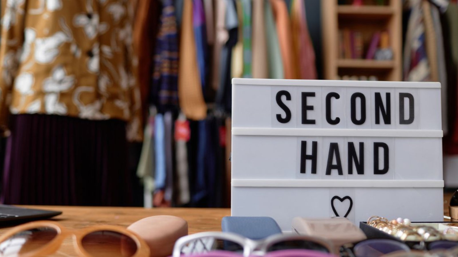 Kleidung auf Tisch mit Schild mit der Aufschrift Second Hand