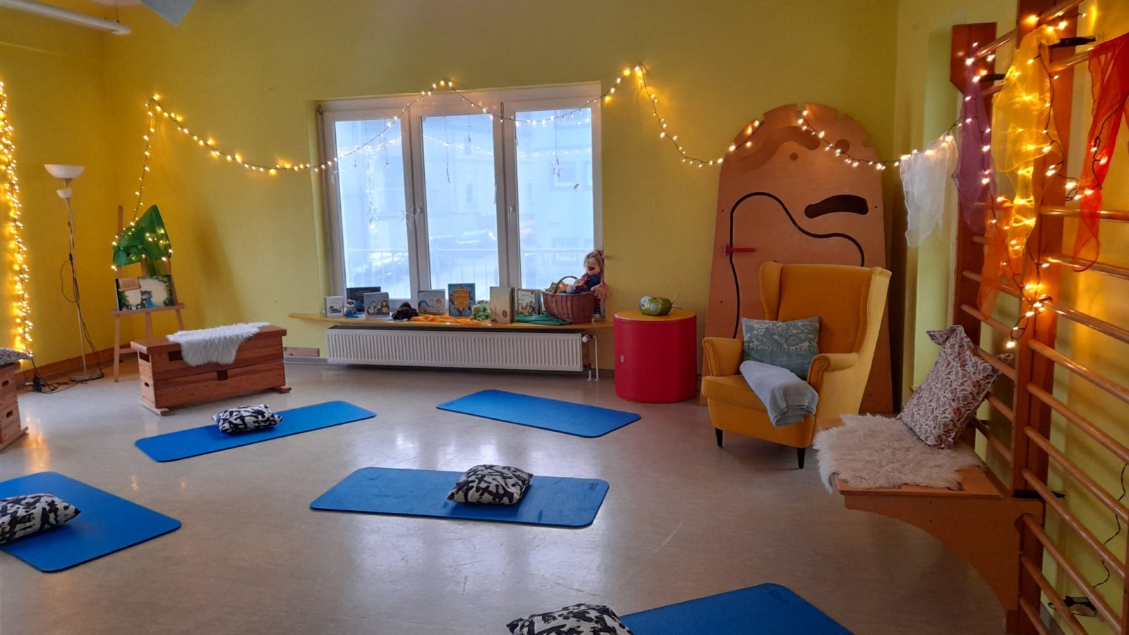 Blick in die Vorleselounge mit Lichterketten, Matten auf den Boden