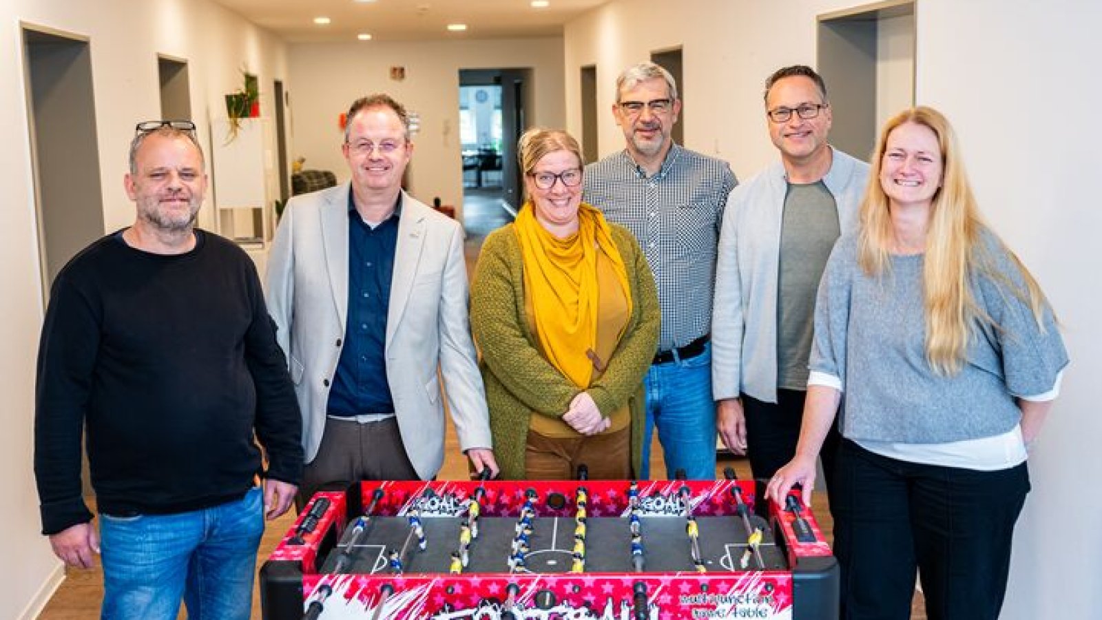 Mehrere Personen stehen vor einem Kicker