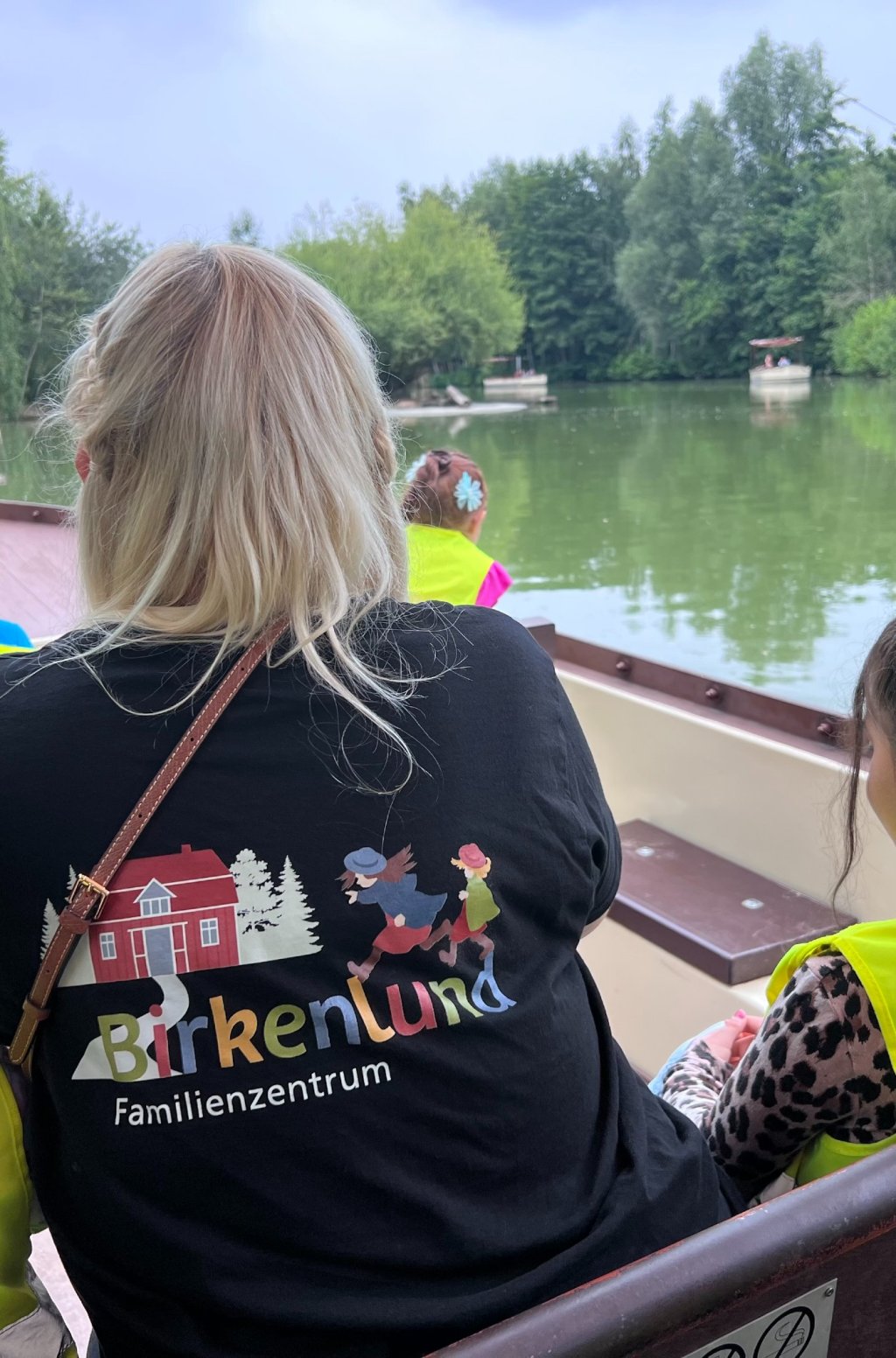 Kind mit Rücken zur Kamera im Boot mit Blick aufs Wasser