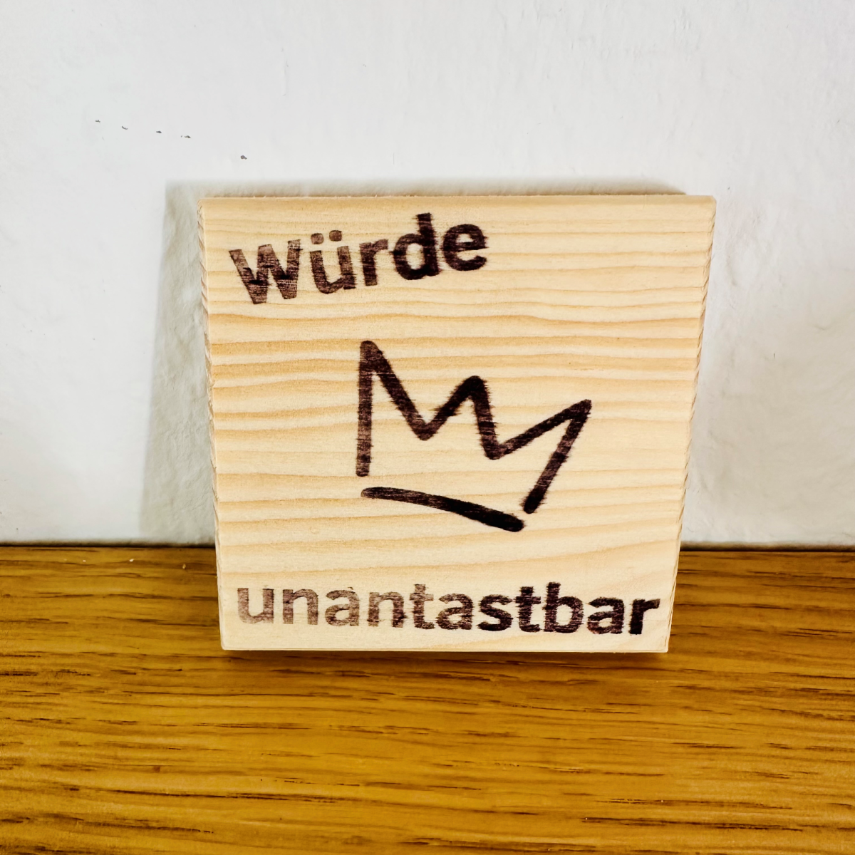 Holztafel mit Krone und Spruch Würde unantastbar