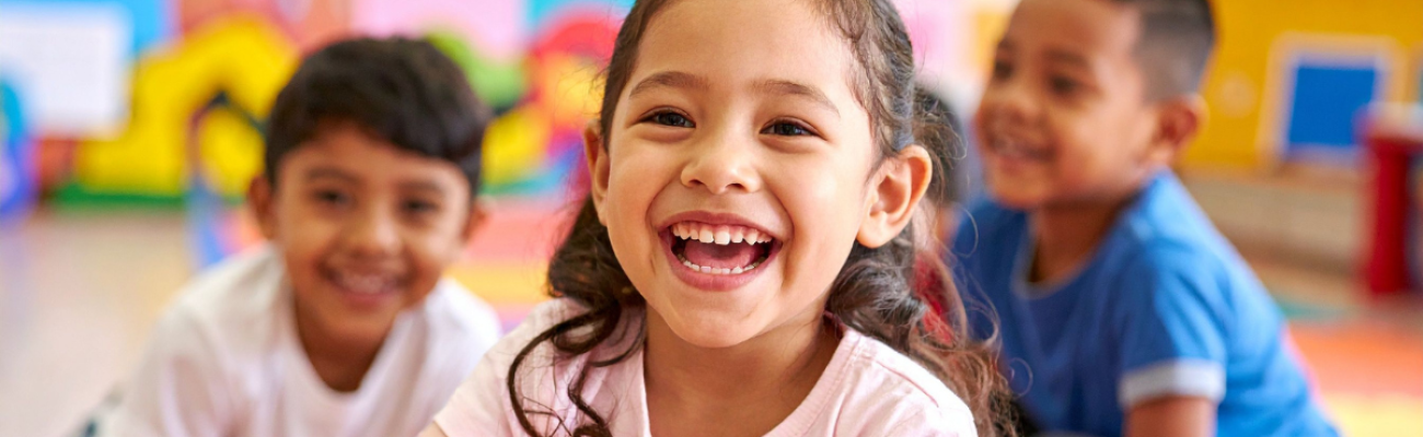 Drei Kinder lachen in die Kamera